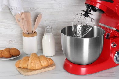 Photo of Modern red stand mixer, croissant, cookies and milk on white marble table