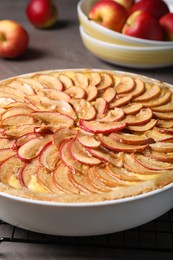 Tasty apple pie in baking dish on grey table, closeup