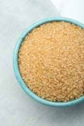 Brown sugar in bowl on table, top view