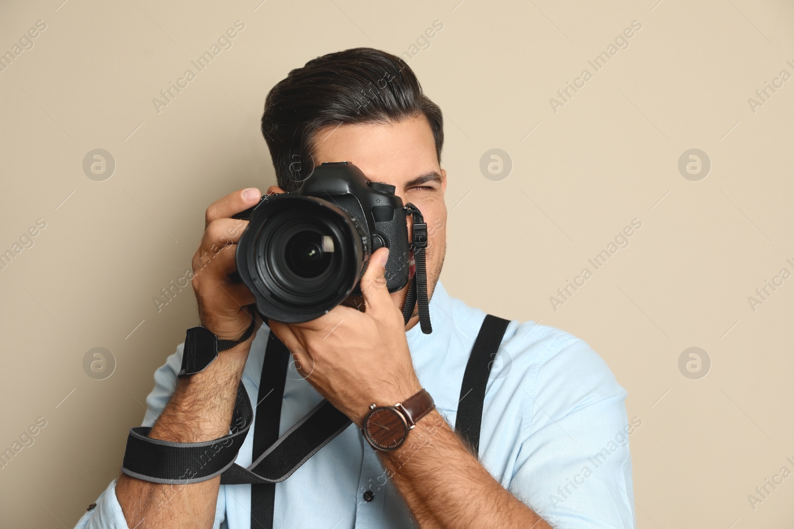 Photo of Professional photographer working on beige background in studio