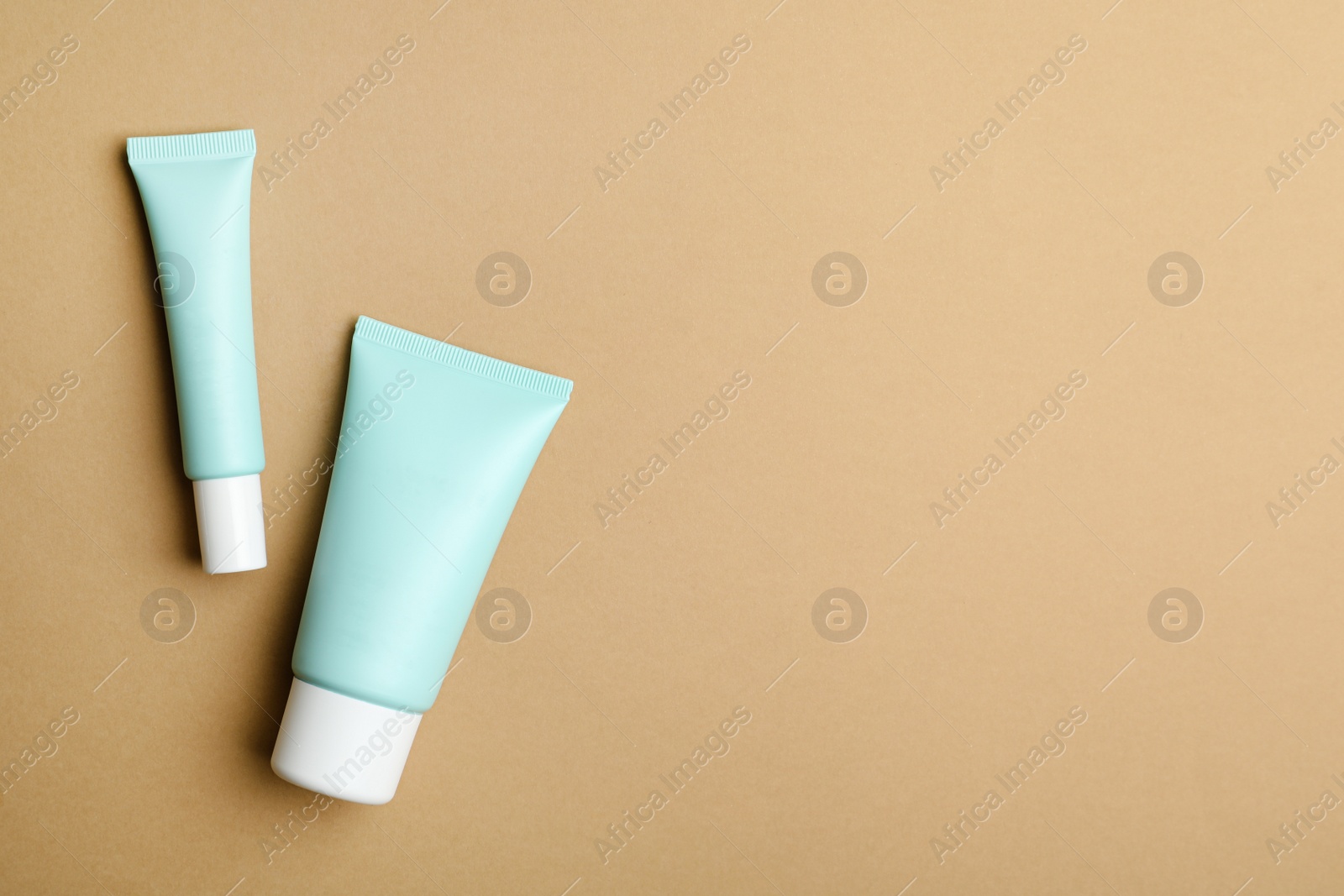 Photo of Set of luxury cosmetic products on light brown background, flat lay. Space for text