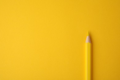 Wooden pencil on yellow background, top view. Space for text