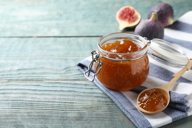 Photo of Homemade delicious fig jam on blue wooden table. Space for text