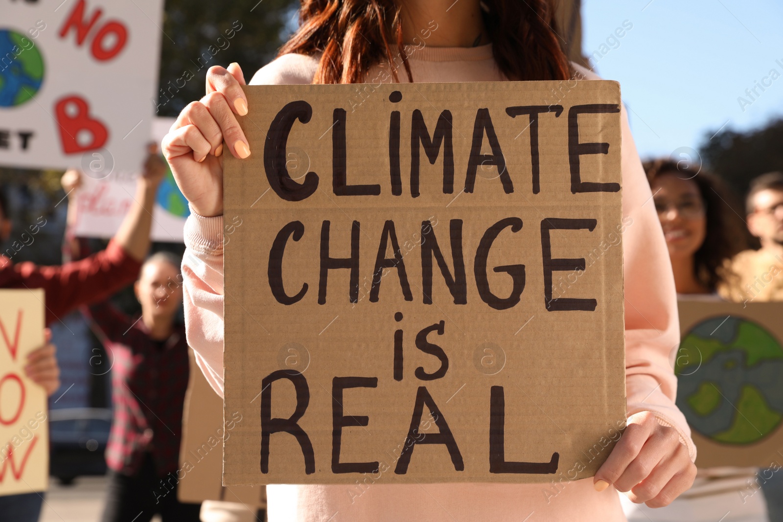 Photo of Woman with poster protesting against climate change outdoors, closeup