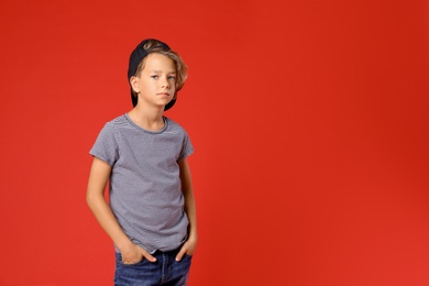 Photo of Cute little boy in casual outfit on red background. Space for text