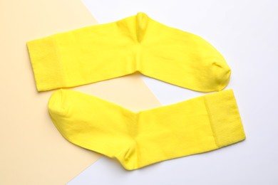 Pair of new yellow socks on color background, flat lay