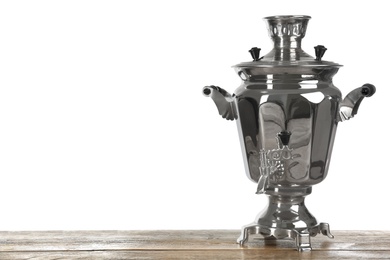 Traditional Russian samovar on wooden table against white background. Space for text