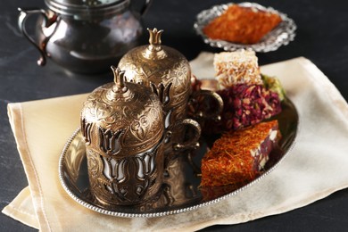 Photo of Tea and Turkish delight served in vintage tea set on dark grey textured table