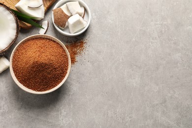 Flat lay composition with natural coconut sugar on light grey table, space for text