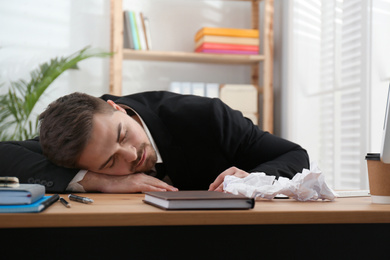 Photo of Lazy employee sleeping at table in office