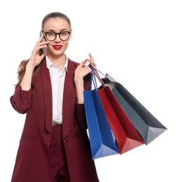 Photo of Stylish young businesswoman with shopping bags talking on smartphone against white background