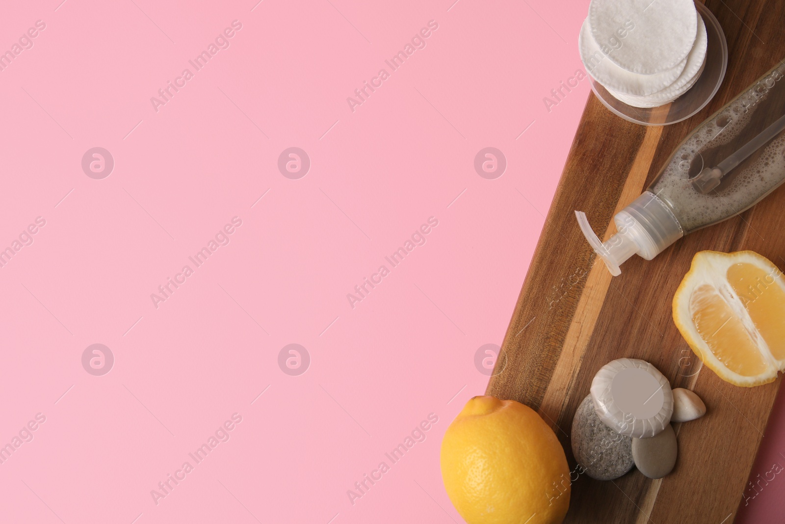 Photo of Lemon face cleanser. Fresh citrus fruits and personal care products on pink background, flat lay with space for text