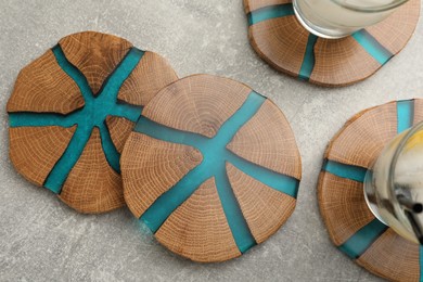 Photo of Cocktail and stylish cup wooden coasters on light grey table, flat lay