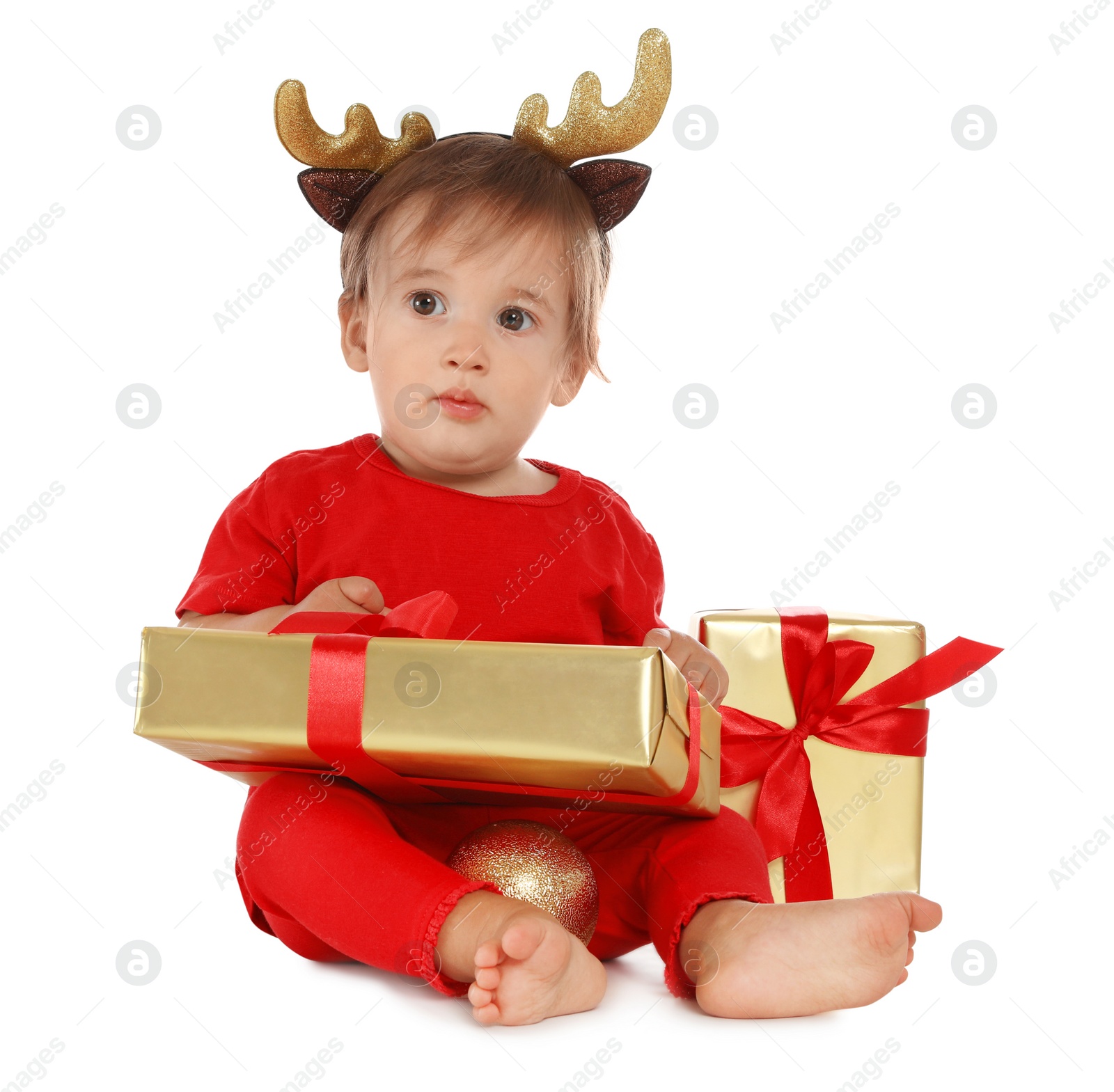 Photo of Festively dressed baby with Christmas gifts on white background