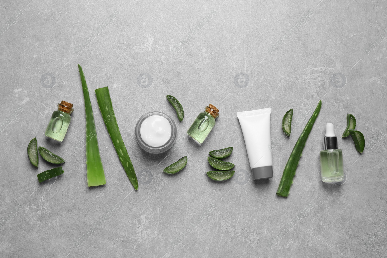 Photo of Flat lay composition with aloe vera and cosmetic products on grey background