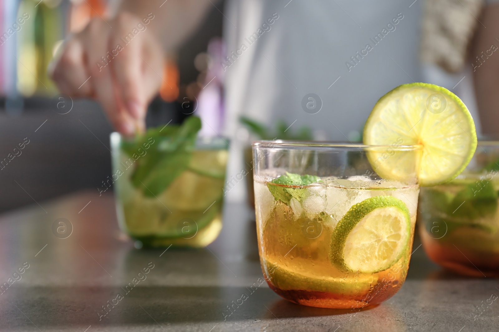 Photo of Glass with delicious mint julep cocktail and blurred person on background