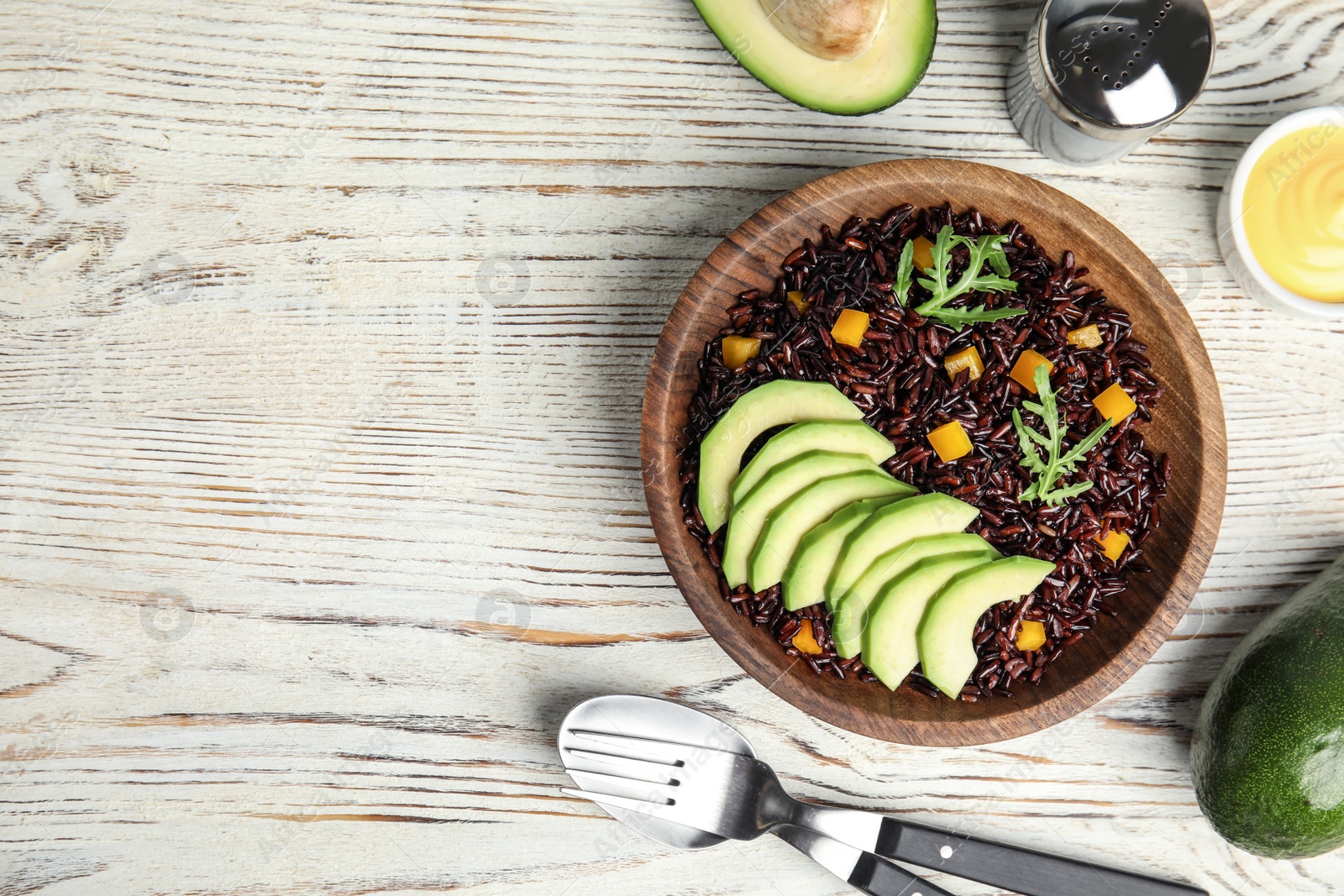 Photo of Flat lay composition with delicious cooked brown rice on white wooden table. Space for text