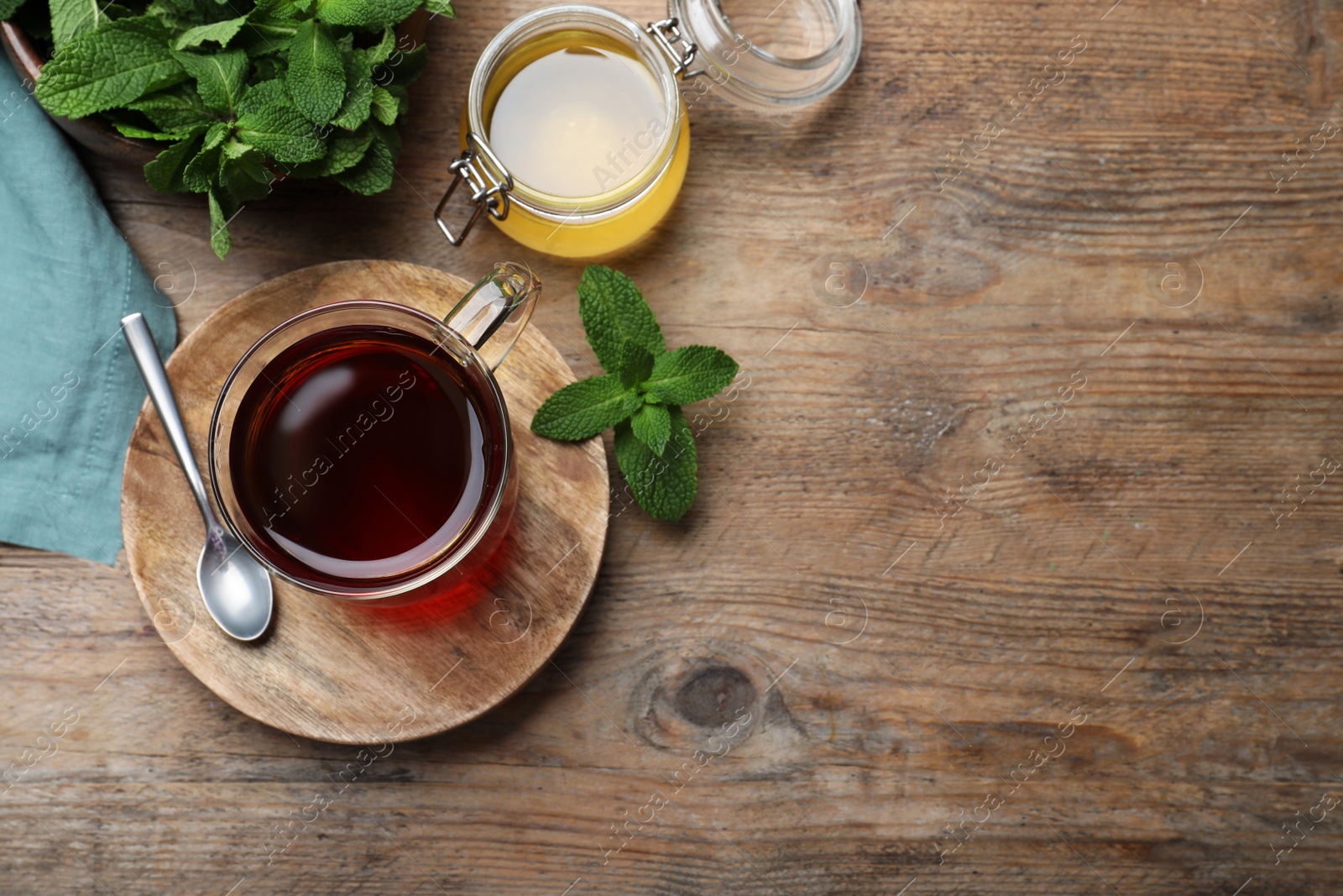 Photo of Cup of hot aromatic tea with mint and honey on wooden table, flat lay. Space for text