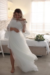 Beautiful bride with her white wedding dress at home