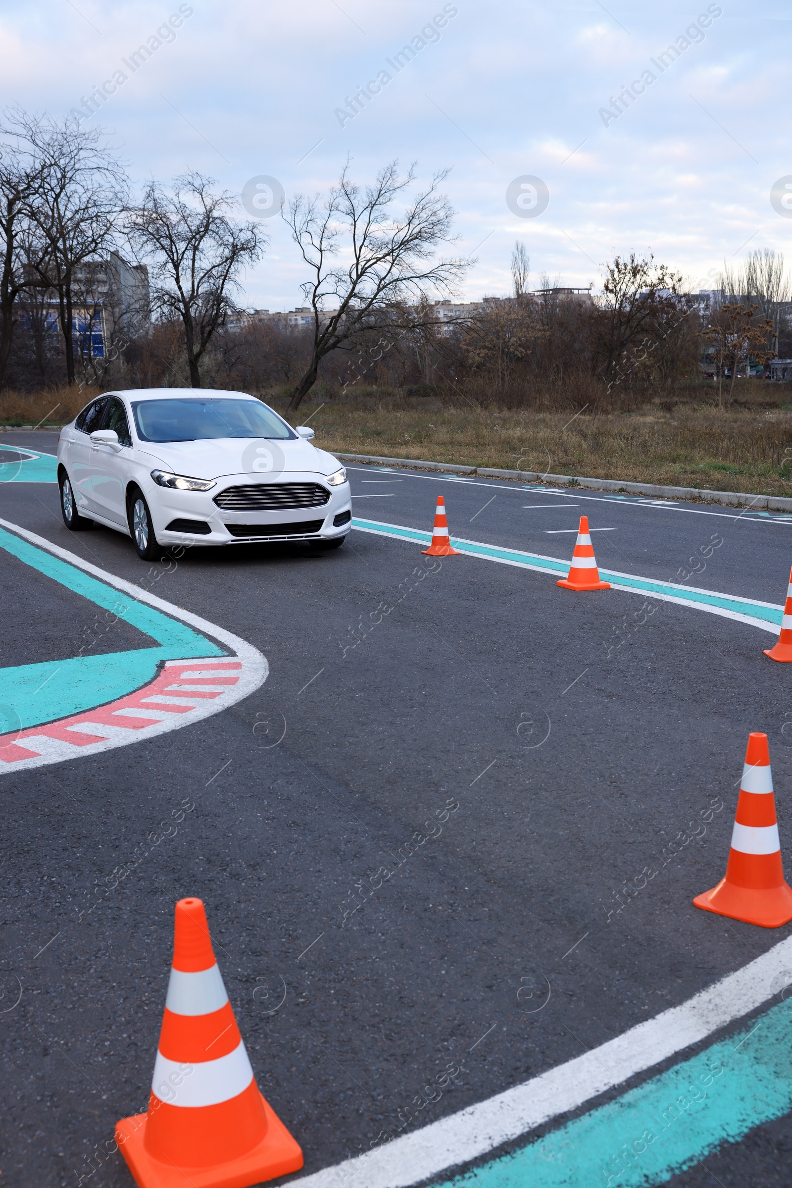 Photo of Modern car on driving school test track with traffic cones