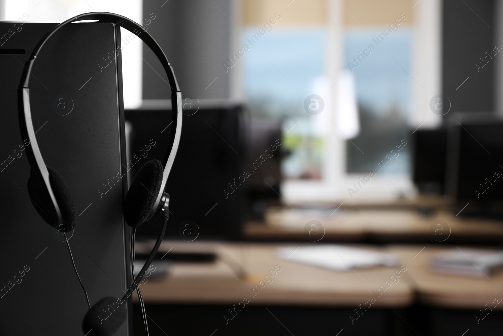 Photo of Modern computer with headset in office. Hotline service