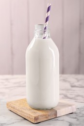 Bottle of tasty milk on white marble table