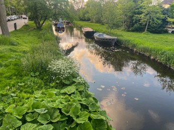 Photo of Beautiful view of canal with moored boats outdoors on spring day