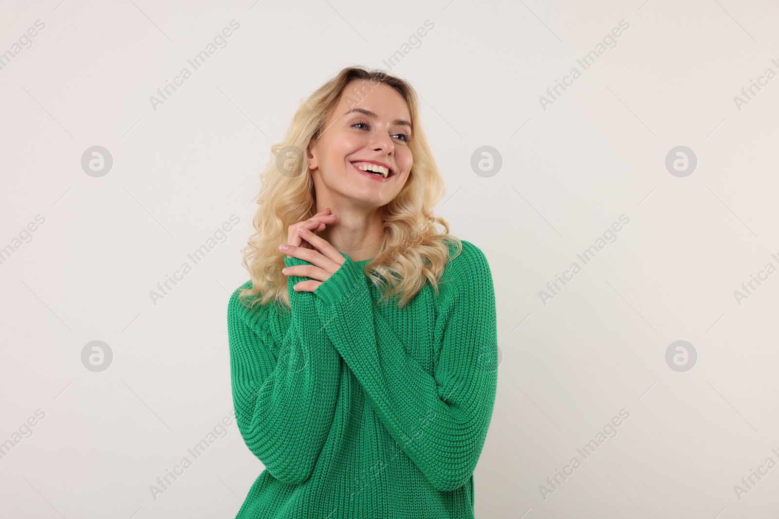 Photo of Happy woman in stylish warm sweater on white background