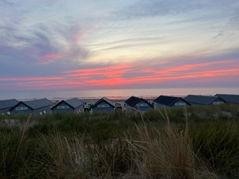 Photo of Many wooden houses on seacoast at sunset