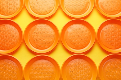 Plastic plates on color background, top view. Picnic table setting