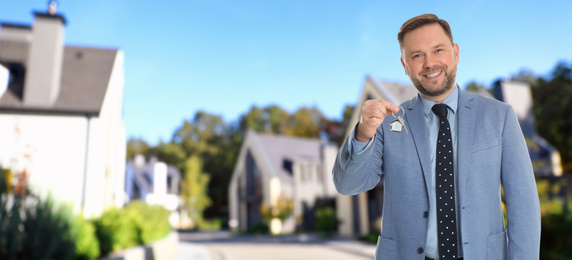 Image of Real estate agent with key against modern houses, space for text. Banner design 