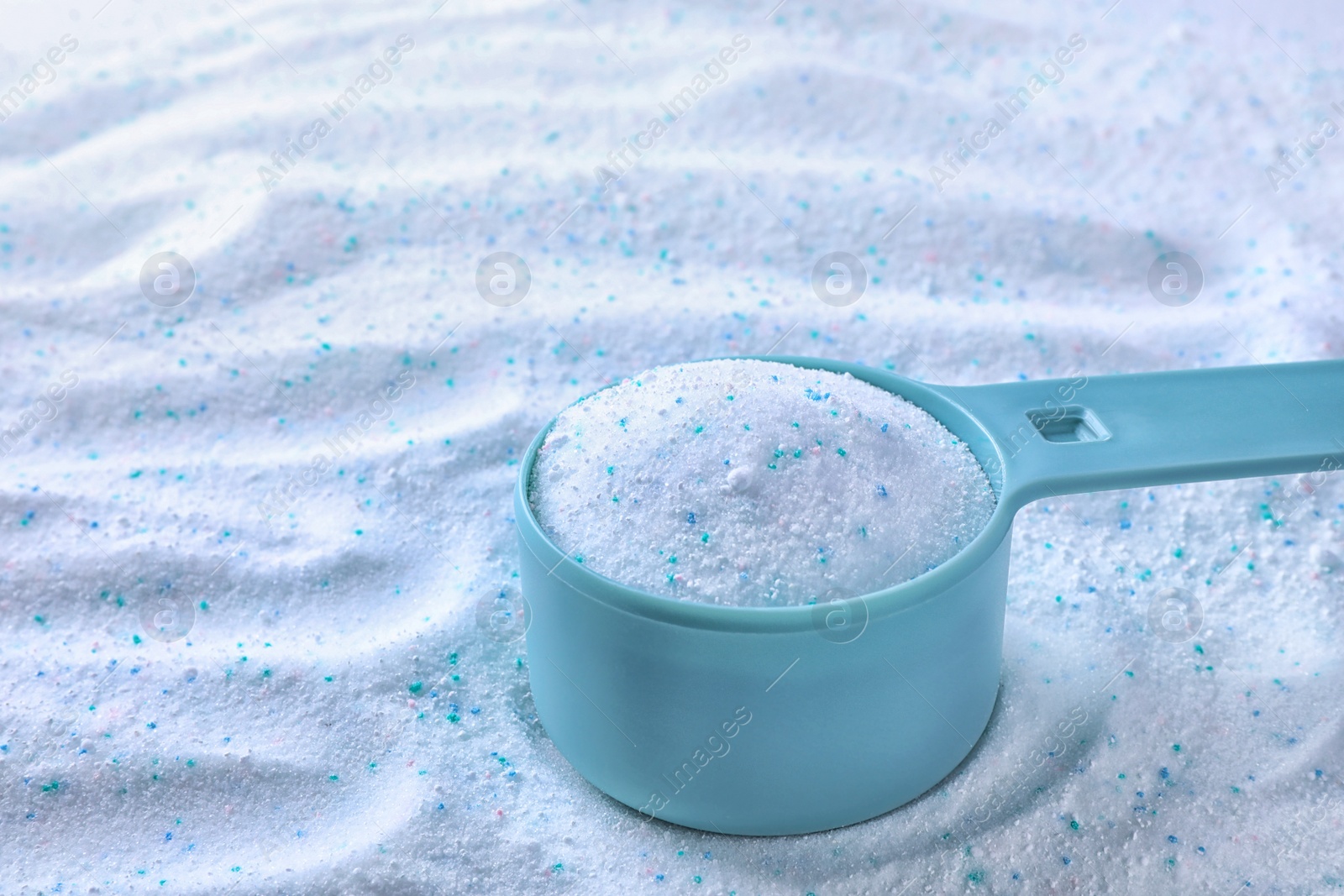 Photo of Measuring spoon with laundry powder, closeup view. Space for text