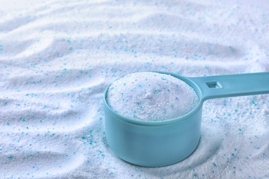 Photo of Measuring spoon with laundry powder, closeup view. Space for text