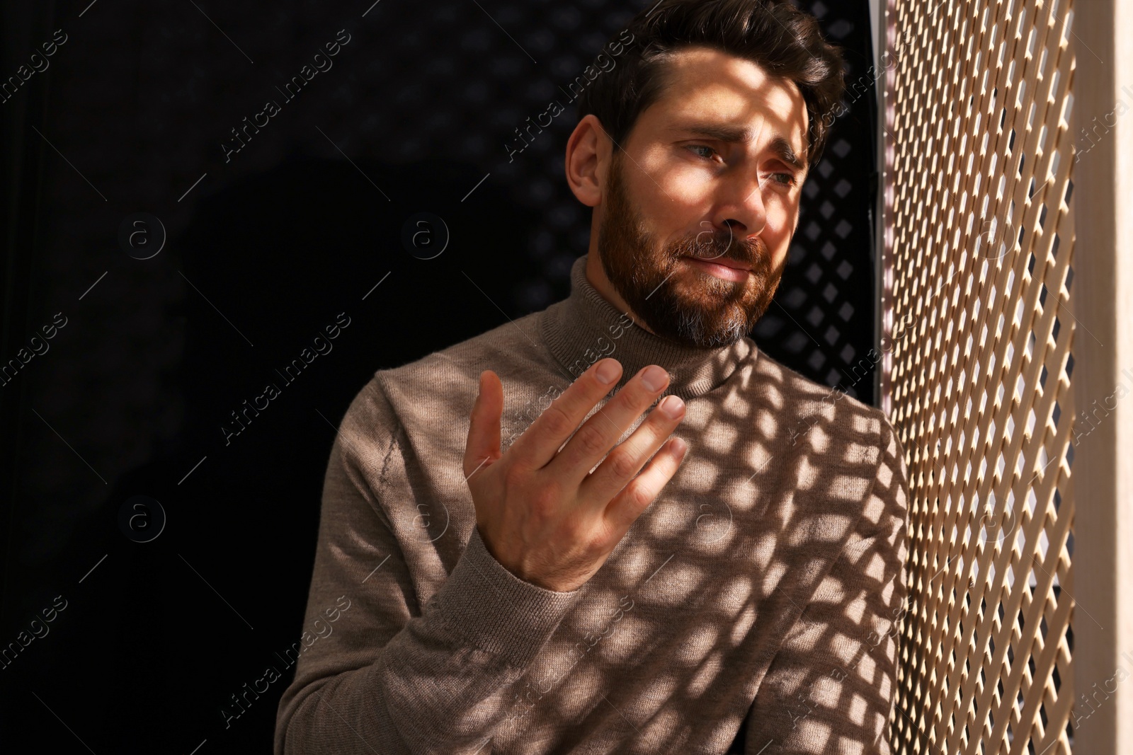 Photo of Upset man talking to priest during confession in booth