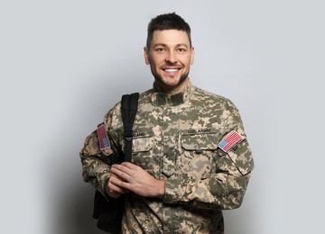 Photo of Cadet with backpack on light grey background. Military education