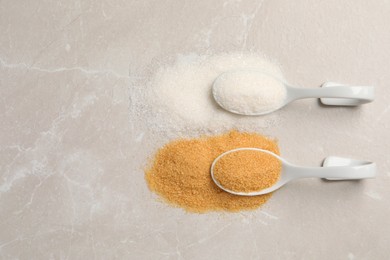 Photo of Spoons with white and brown sugar on light marble table, flat lay. Space for text