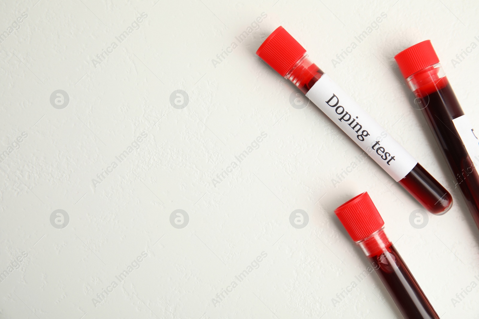 Photo of Test tubes with blood samples and space for text on beige background, flat lay. Doping control