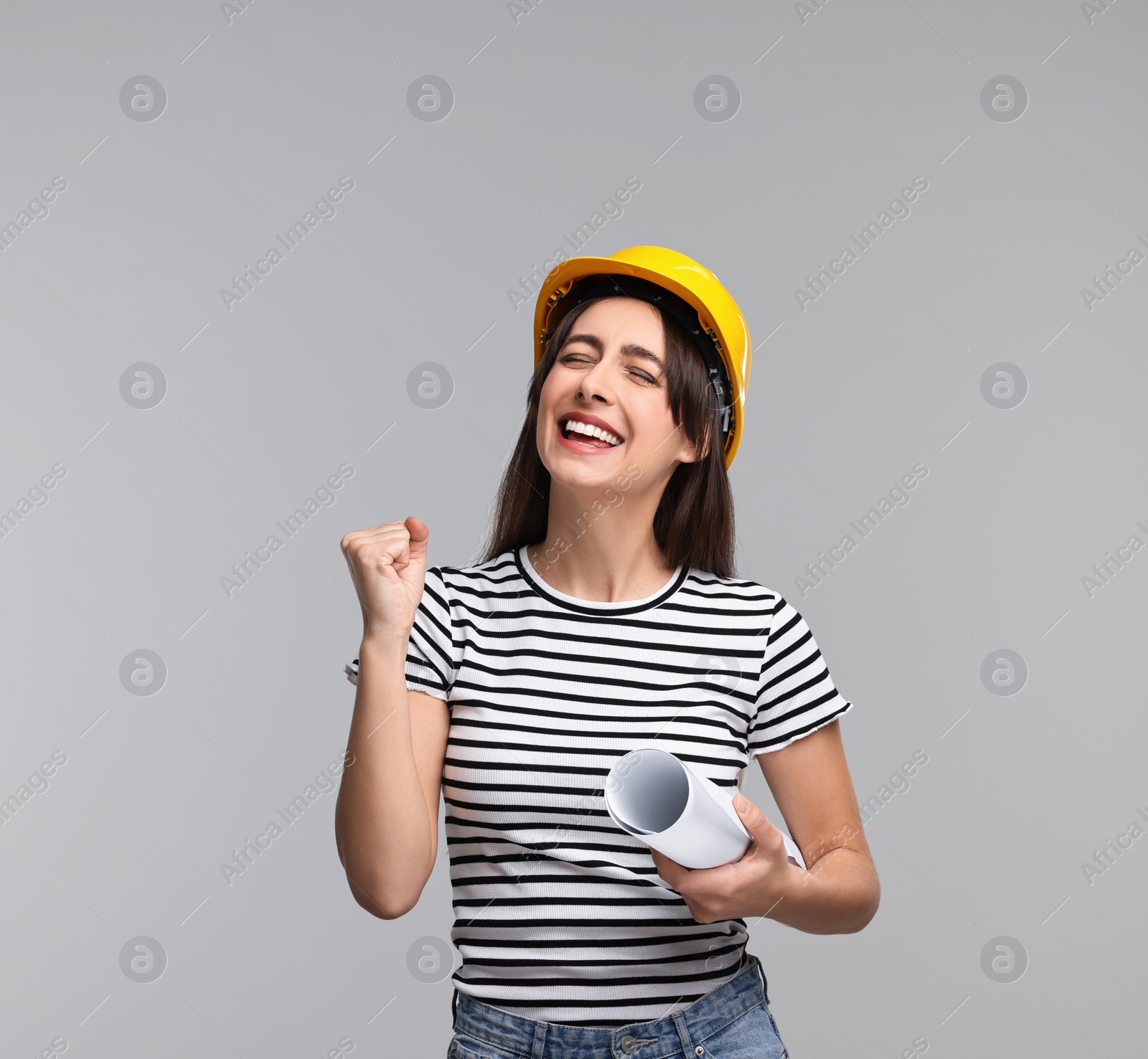 Photo of Architect with hard hat and draft on light grey background