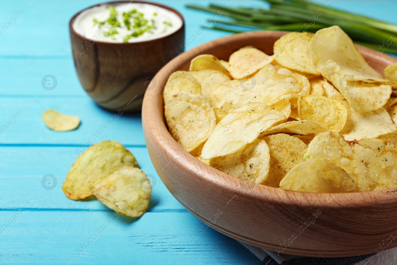 Photo of Sour cream and chips on blue wooden table