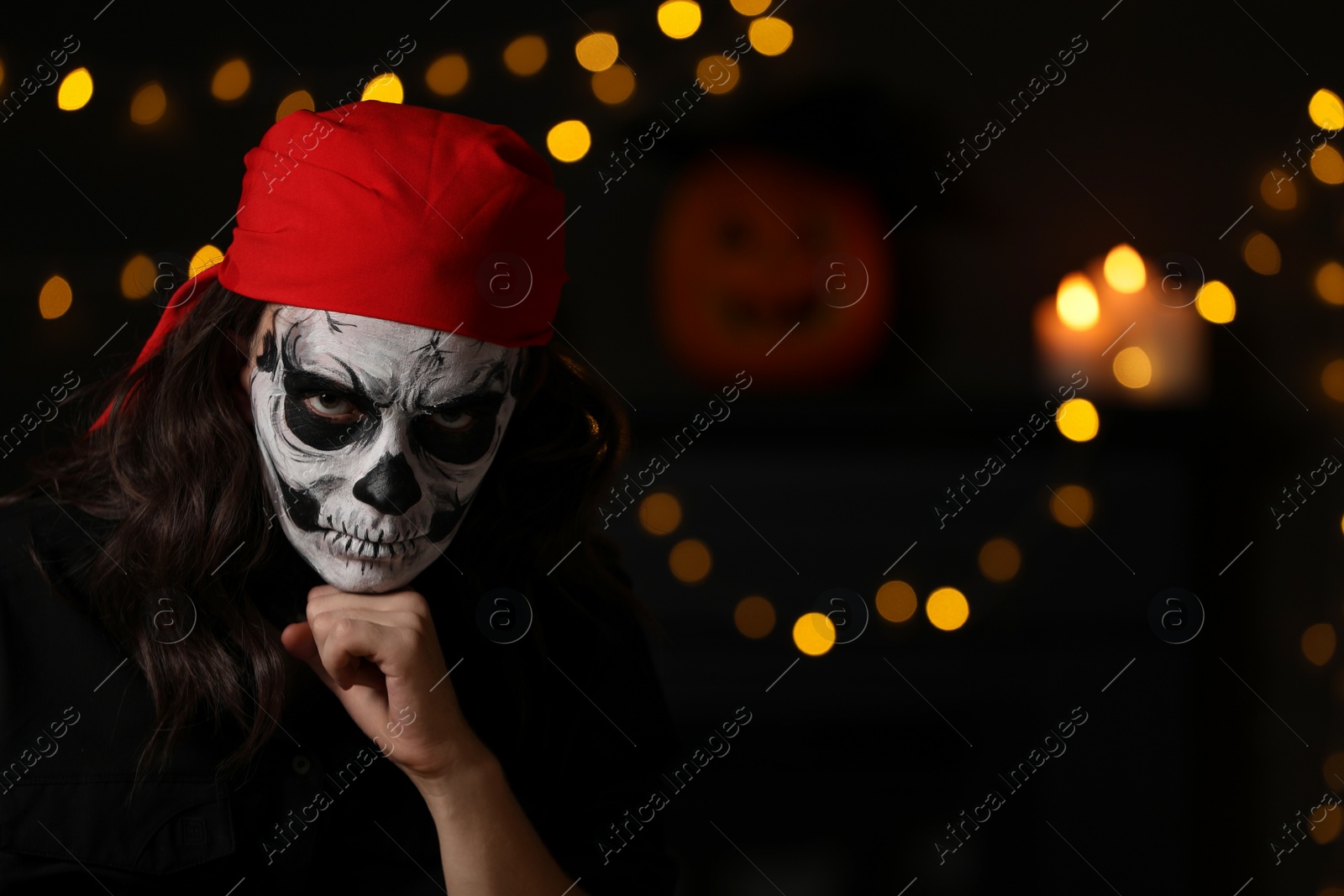 Photo of Man in scary pirate costume with skull makeup against blurred lights indoors, space for text. Halloween celebration