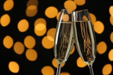 Photo of Glasses of champagne against blurred lights. Space for text