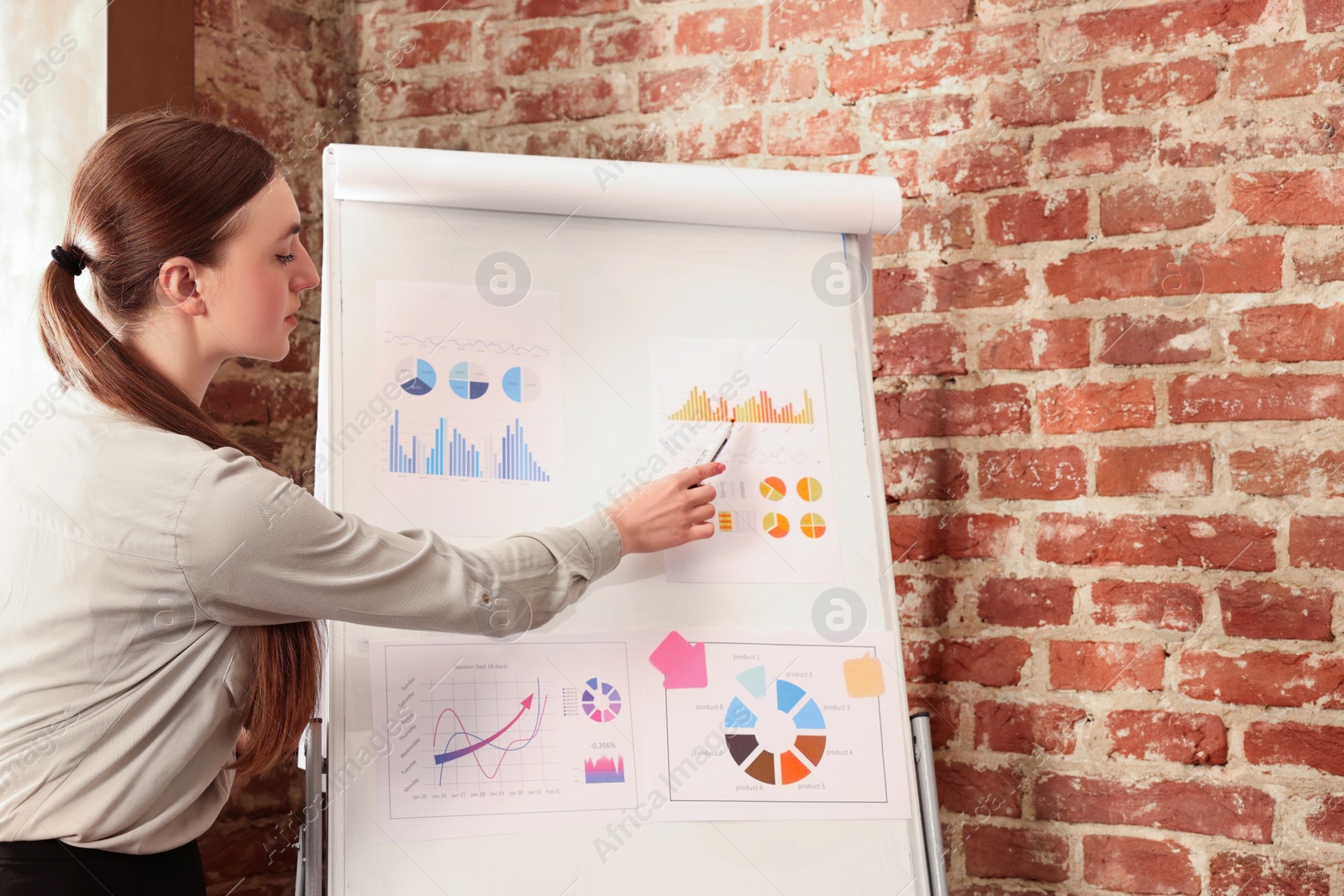 Photo of Businesswoman showing presentation with charts in office