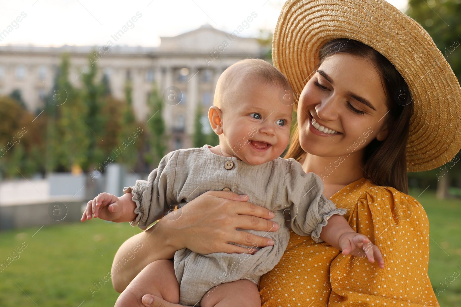 Photo of Happy mother with adorable baby walking on sunny day