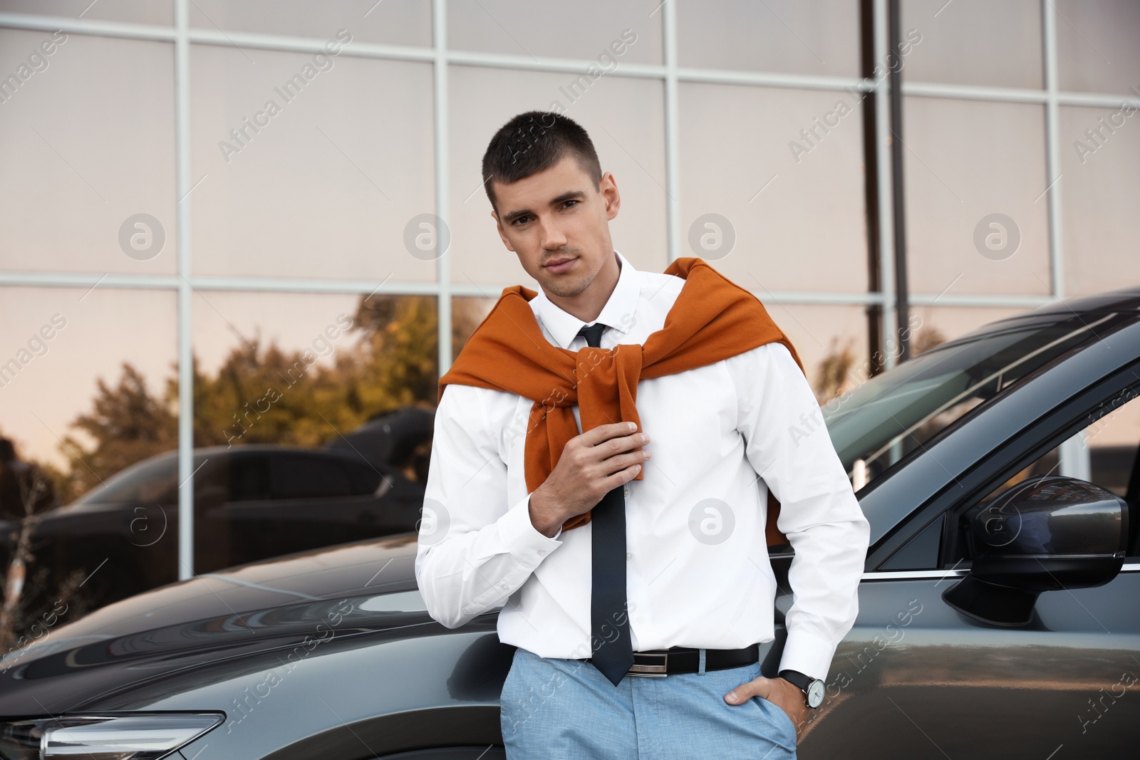 Photo of Attractive young man near luxury car outdoors