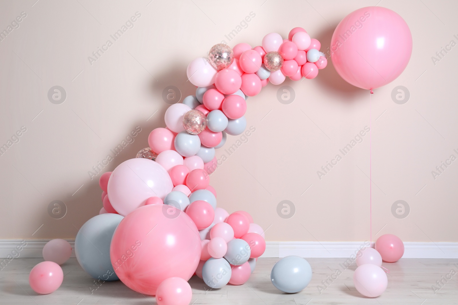 Photo of Beautiful composition with balloons near beige wall