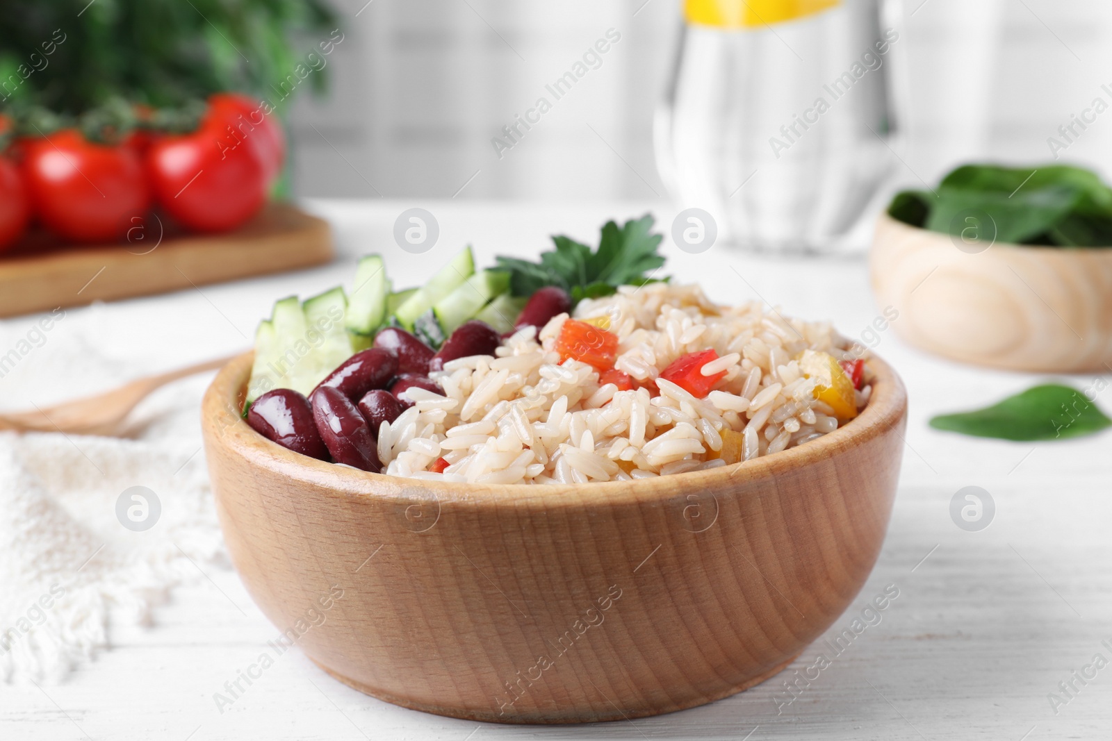 Photo of Delicious rice with beans served on white wooden table, closeup