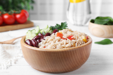 Photo of Delicious rice with beans served on white wooden table, closeup