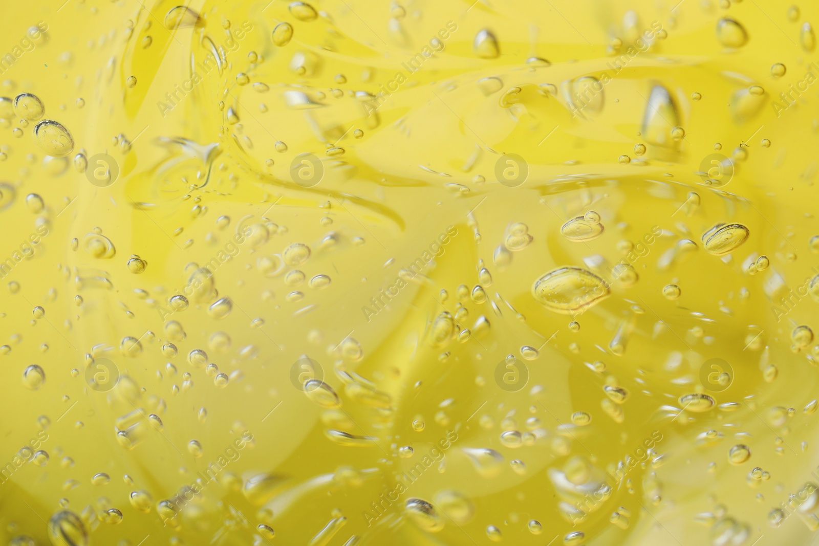 Photo of Pure transparent cosmetic gel on yellow background, closeup