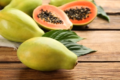 Fresh ripe papaya fruits on wooden table. Space for text