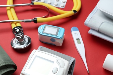 Photo of Digital pressure meter and medical objects on color background